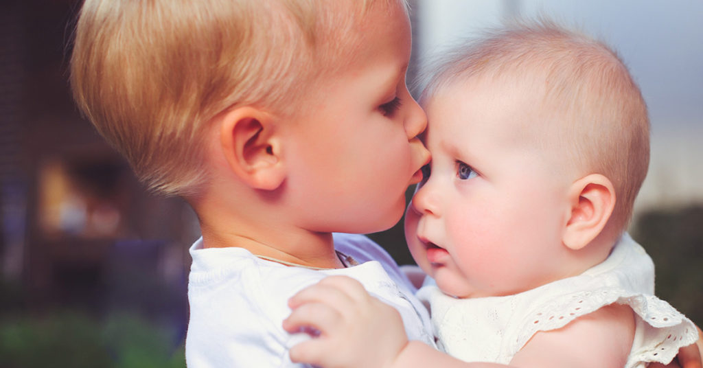 2-year-old immediately calms crying baby sister in viral video - Featured image