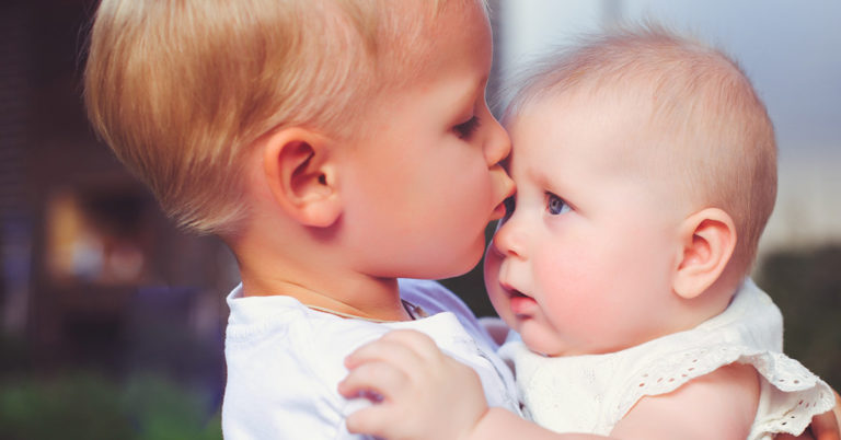 2-year-old immediately calms crying baby sister in viral video - Featured image