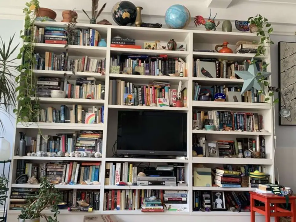 cluttered bookshelf with television 
