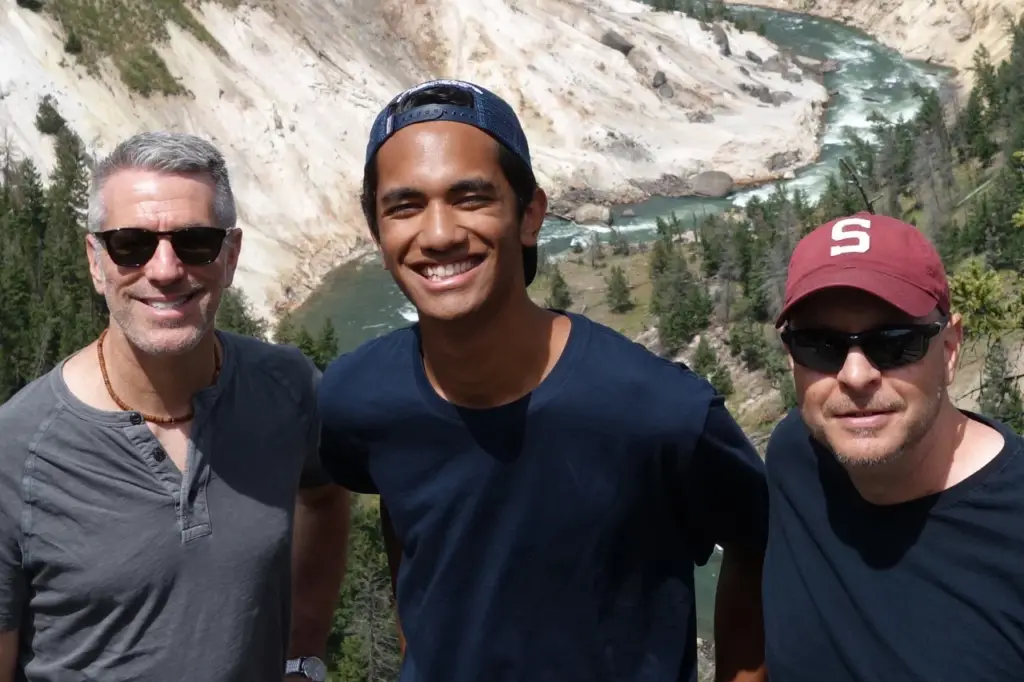 Pete, Danny, and their adopted son Kevin on a hike. A river can be seen in the background. 