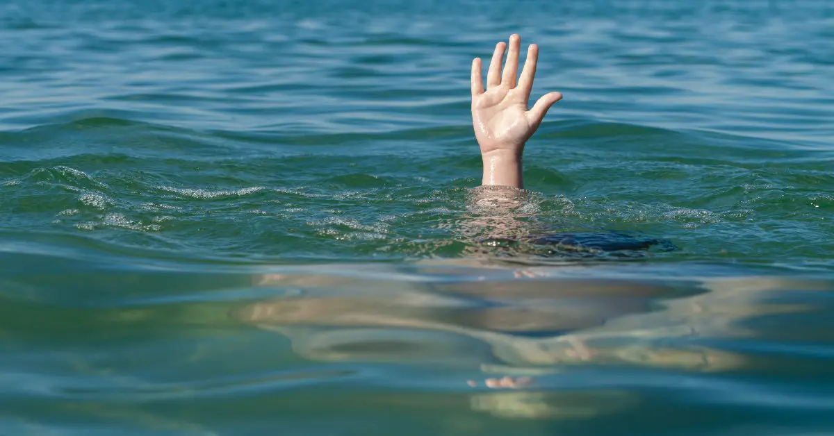 one hand extended out of a body of water from below