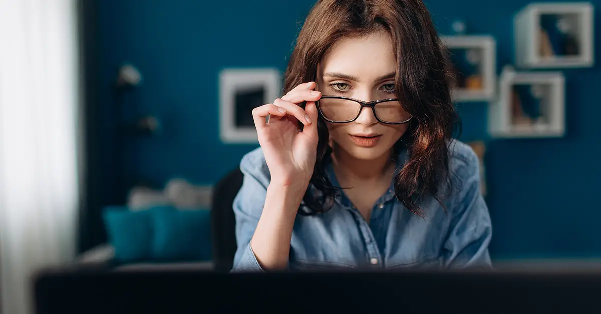 woman with glasses looking at screen