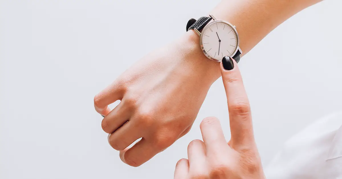 person pointing to their watch