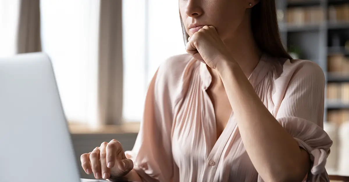 woman staring at a computer thinking