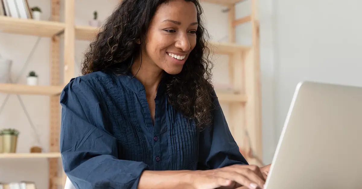 woman smiling and looking at laptop