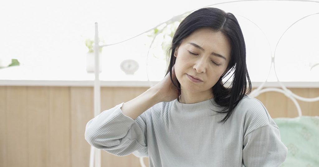 woman holding neck in pain