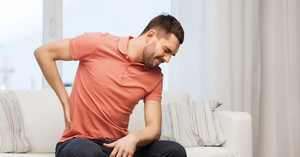 man holding lower back in pain
