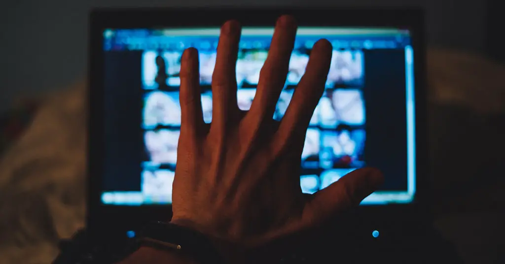hand attempting to block view of computer screen