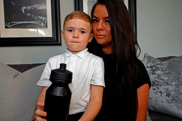 boy and his mom. Boy holding a black water bottle