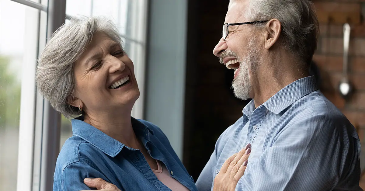 an elderly man and woman laughing