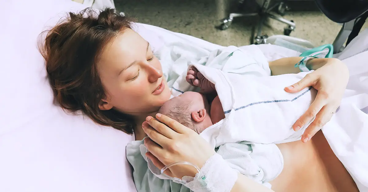 woman holding her child after birth