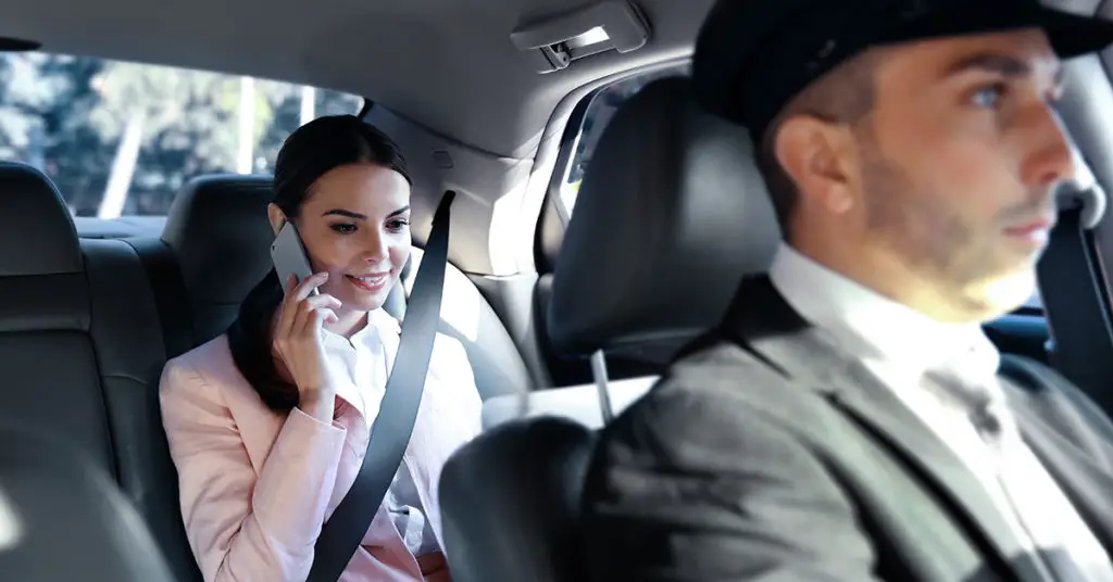 business woman in back seat of car on phone