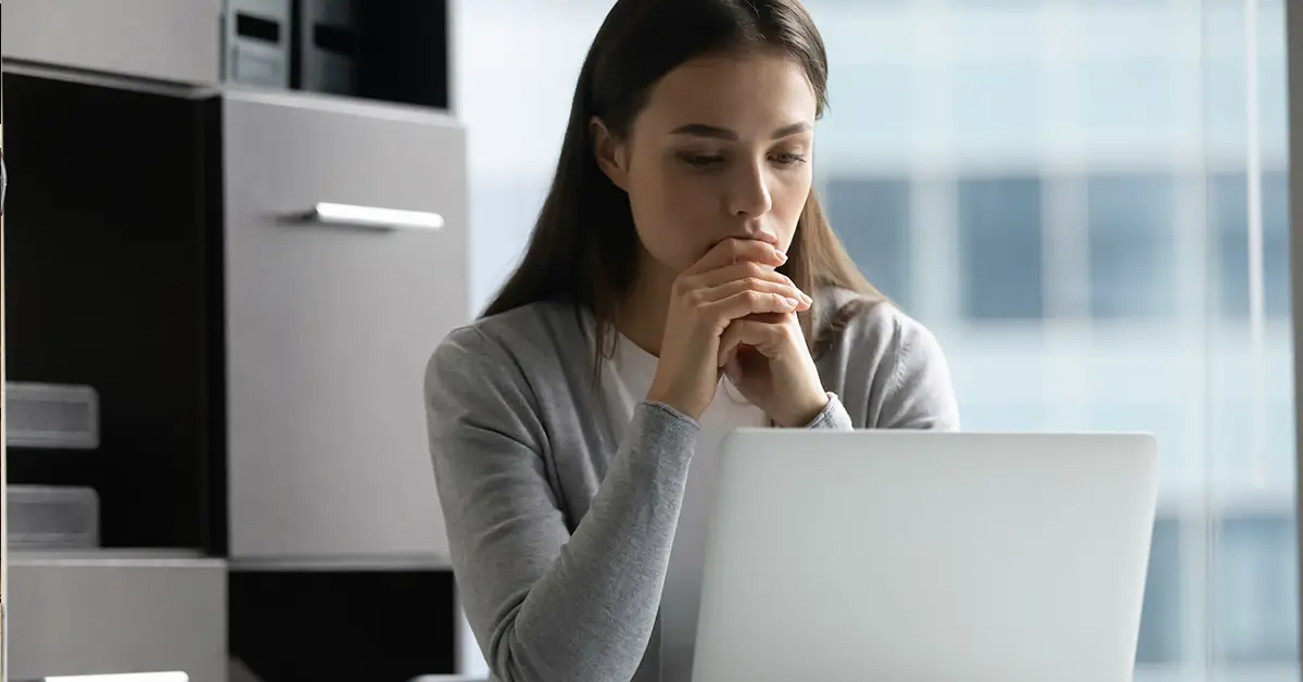 woman thinking while using laptop