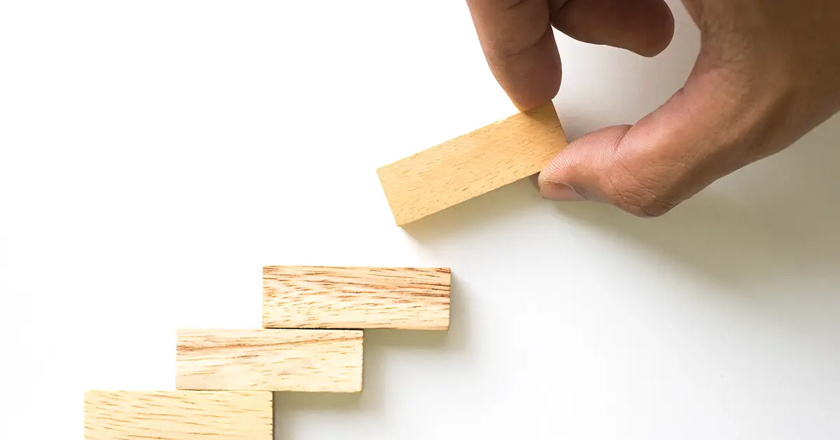 stacking wooden game pieces on top of eachother in a stair like pattern