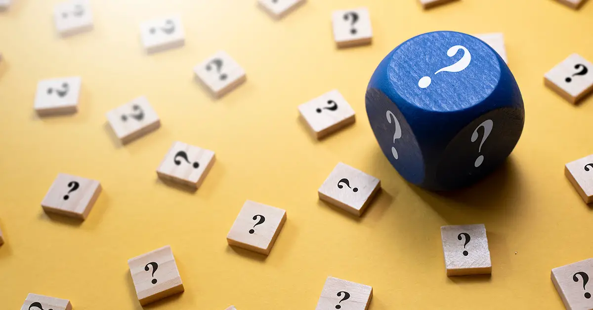 square white wooden game prices with question marks on them with one large blue die with white question marks on each side
