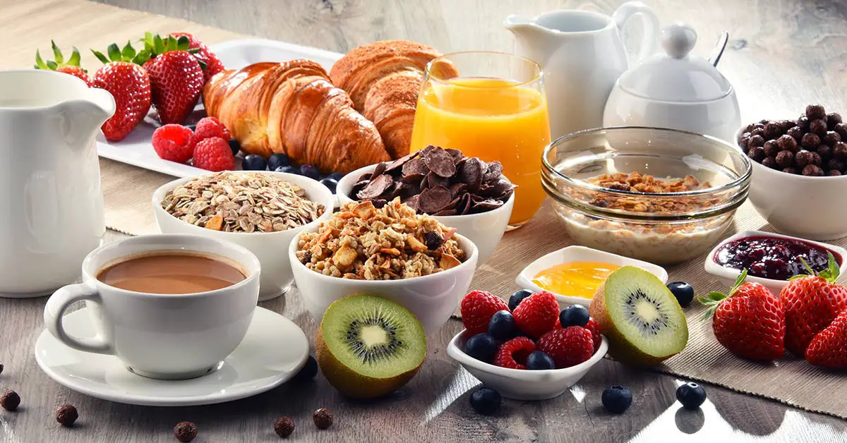 stock photo of a variety of breakfast items including coffee fruit, croissants, granola etc.