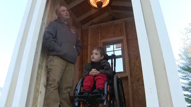 Ryder on his wheelchair and his father waiting in "Ryder's Bus Stop"