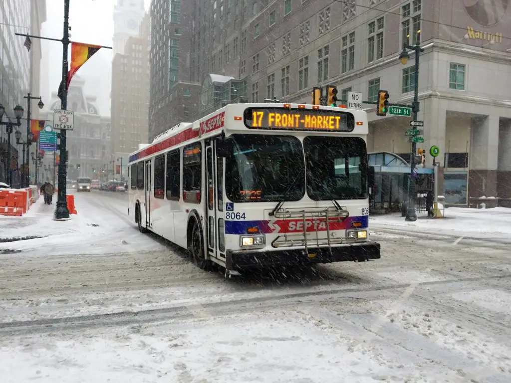 photo of a bus driving through the snow
