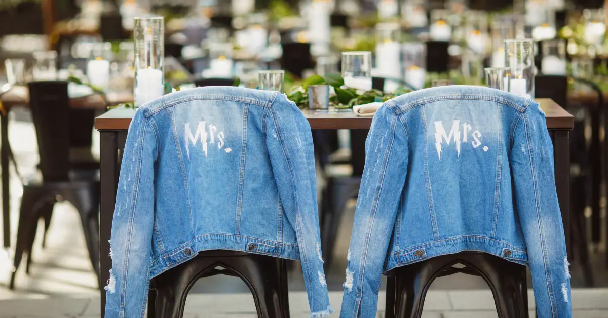 two jean jackets draped over chairs at an outdoor function