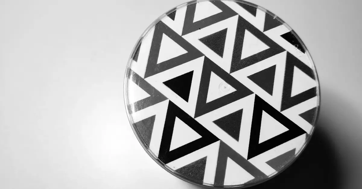 a circular pin wit a black and white triangle design