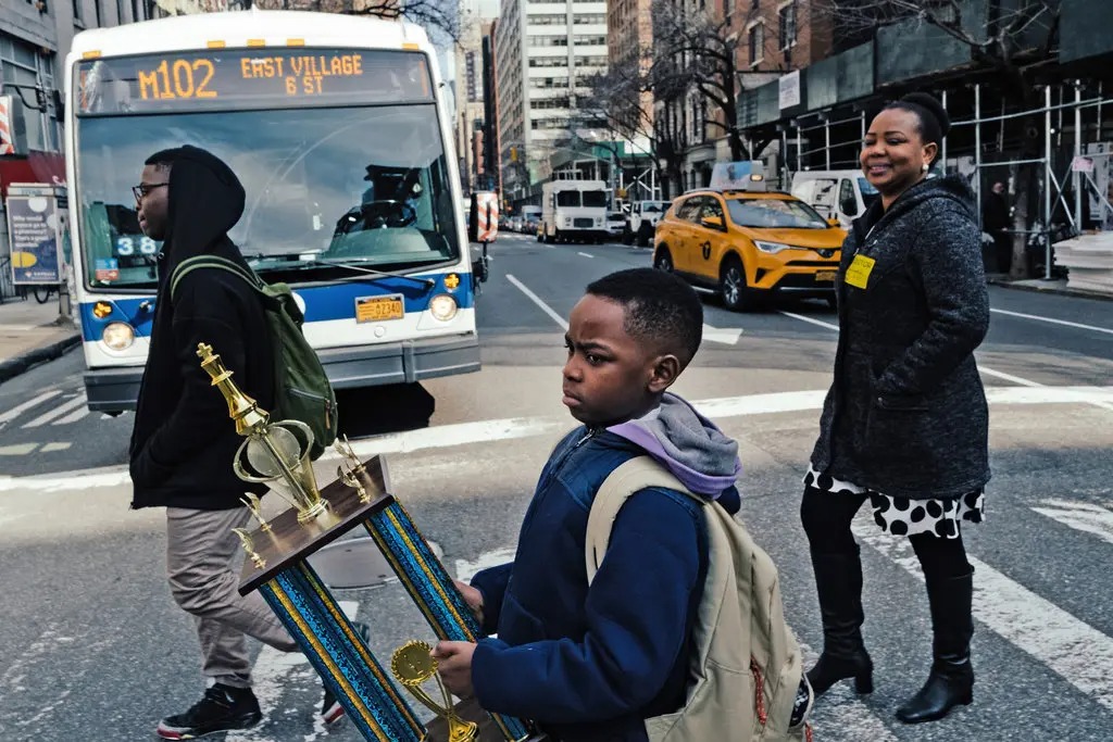 Tani(middle), his brother, and his mother with his New York State Chess Championship trophy in 2019.