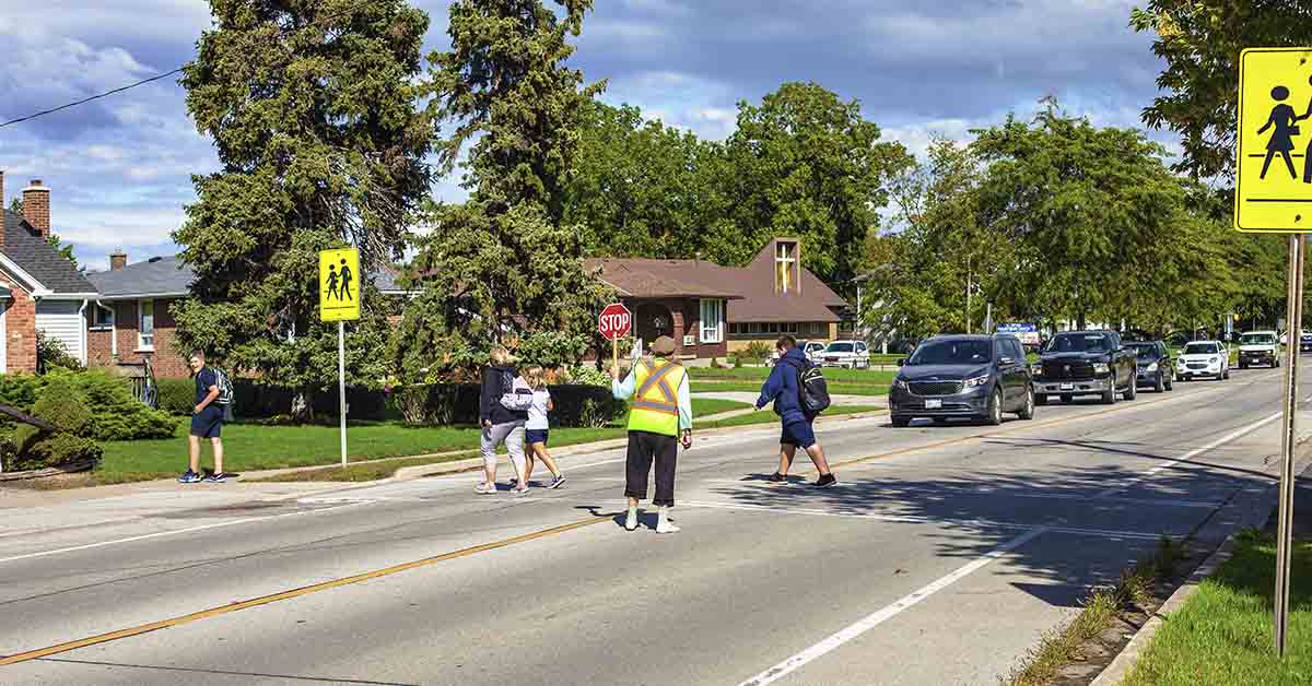school crossing guard helping pedestrians cross the street