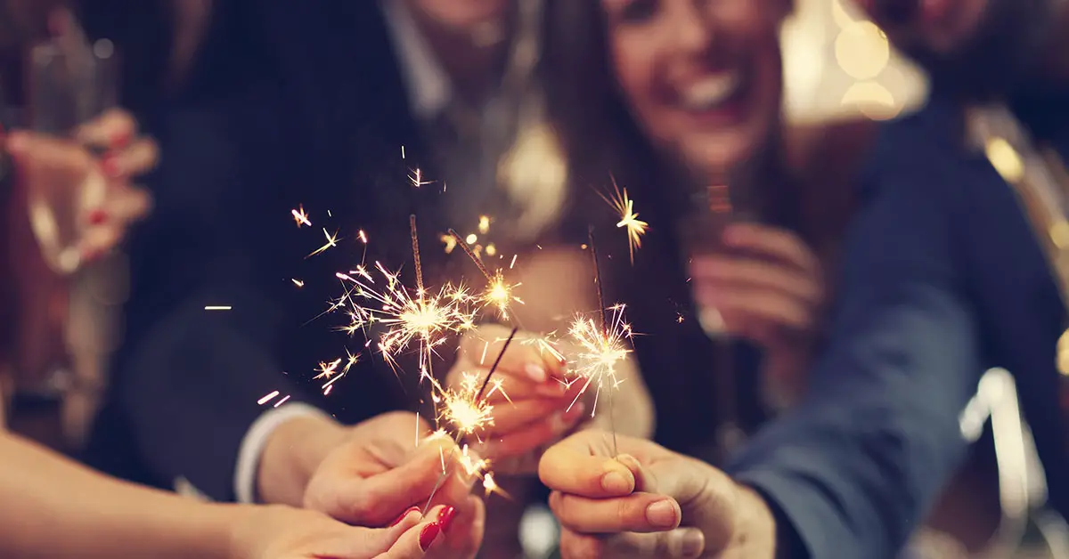 group of people holding sparklers celebrating
