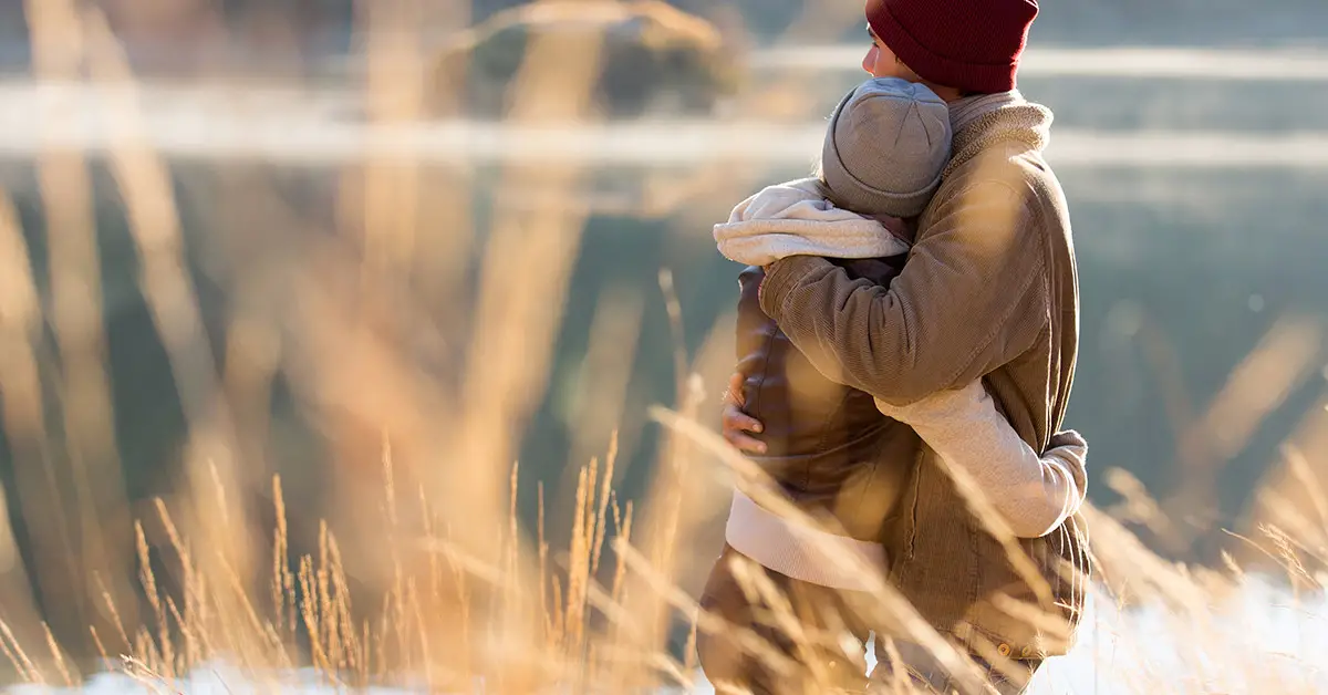 woman hugginh child outdoors