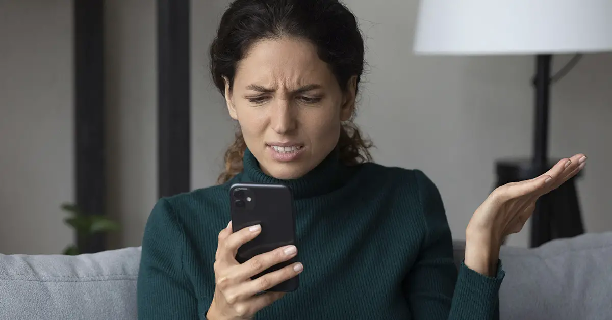 woman distraught looking at phone