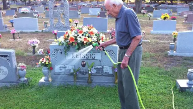 Jake Reissig watering his wife's grave plot