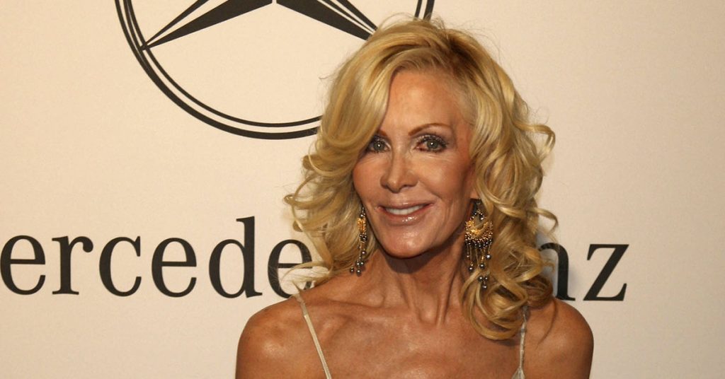 Recognize her? Better sit before you learn her true identity… - Featured image