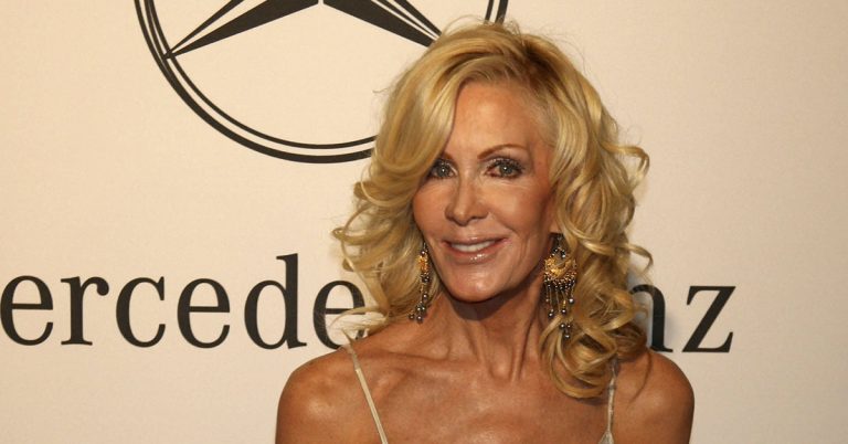 Recognize her? Better sit before you learn her true identity… - Featured image