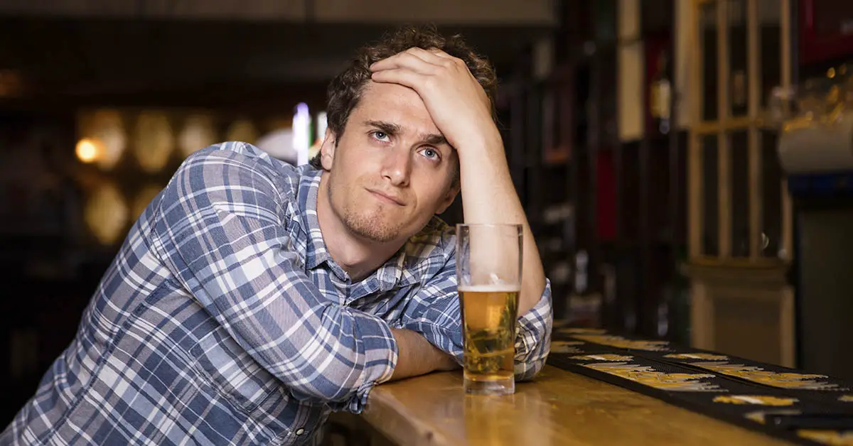 disappointed man at bar with beer