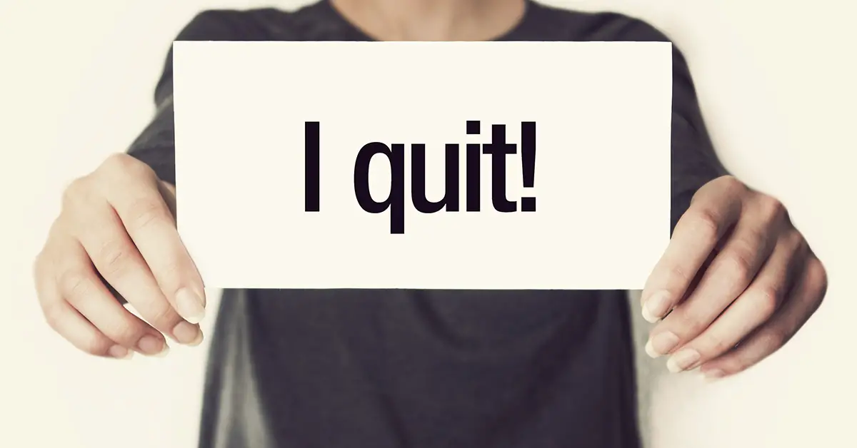 person holding sign saying "I quit"