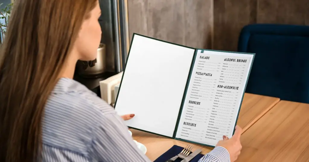 Young woman looking through menu in restaurant
