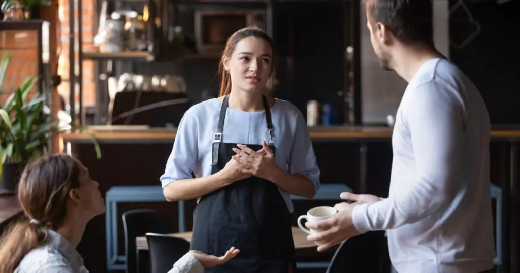 Hostile angry restaurant client couple or friends talking with waiting staff in public place complains about cold coffee long service, spoiled tasteless dish waitress feels guilty mixed orders concept
