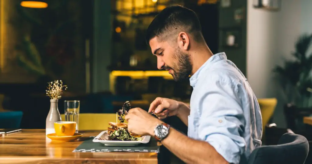 man having breakfast or dinner in cafe
