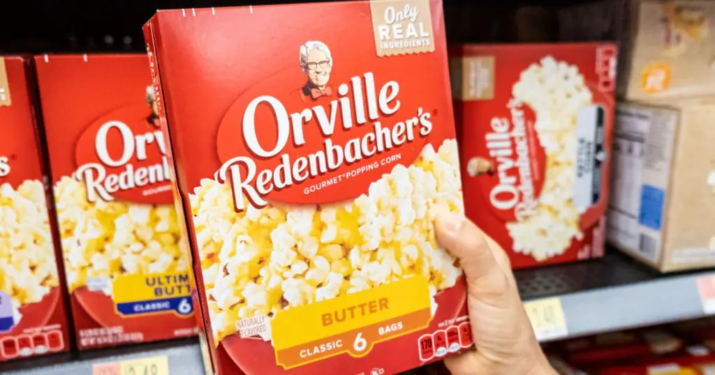 Los Angeles, CA/USA 08/09/2019 Shoppers hand holding a carton box of Orville Redenbacher's brand popcorn in a supermarket aisle
