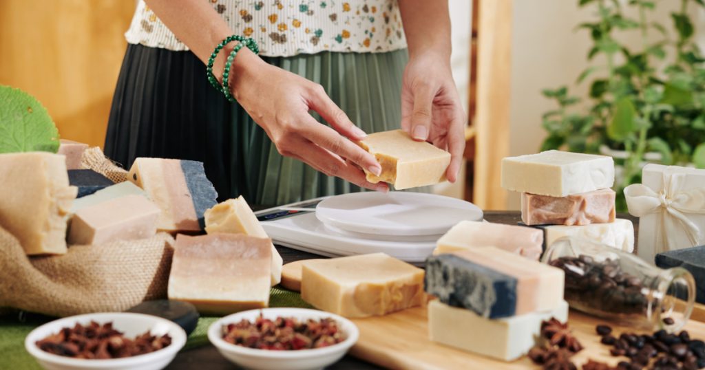 Woman cutting handmade soap in pieces and packing it for customers
