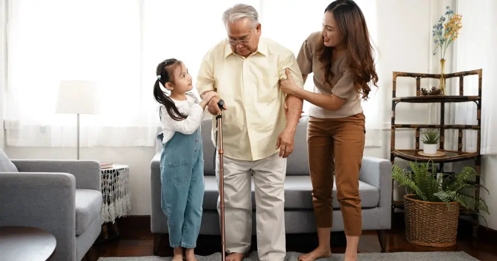 Happy Family Multi-generation Mother and daughter taking care of the senior grandfather help walking together in the house happiness, Elderly retirement concept.
