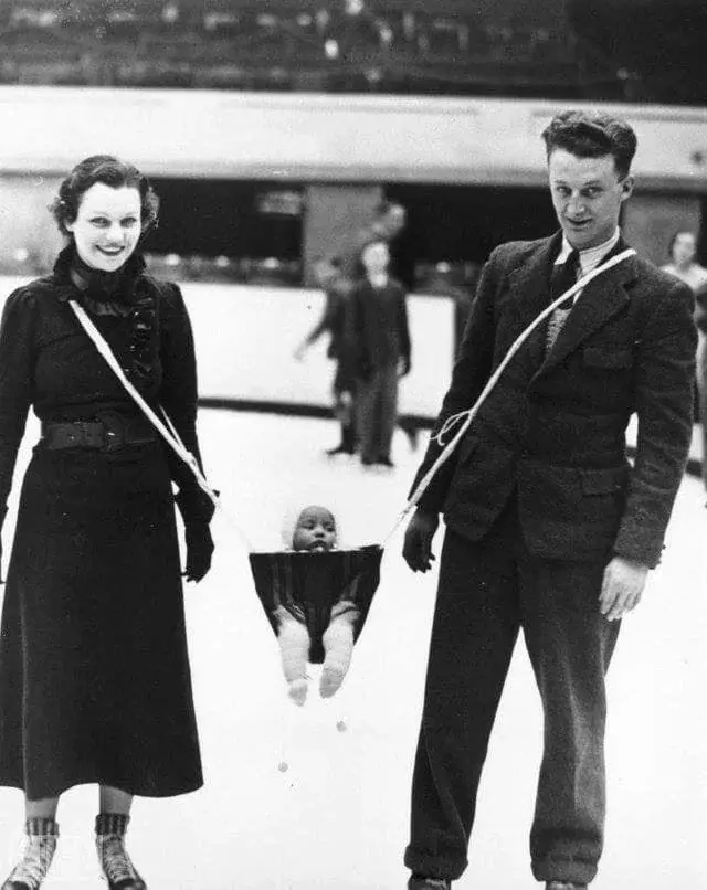 parents ice-skating with baby in a hammock