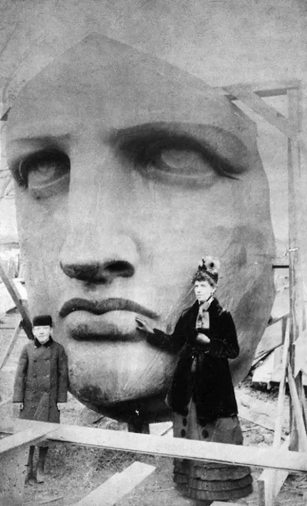 mother and her child posing beside the face of Lady Liberty before she was lifted high up into the sky.