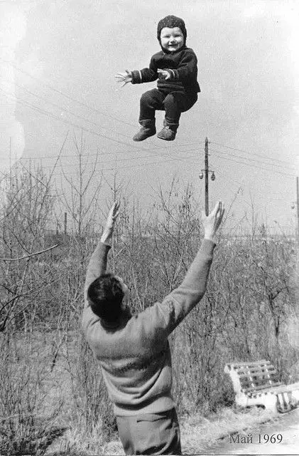 child being tossed air by father