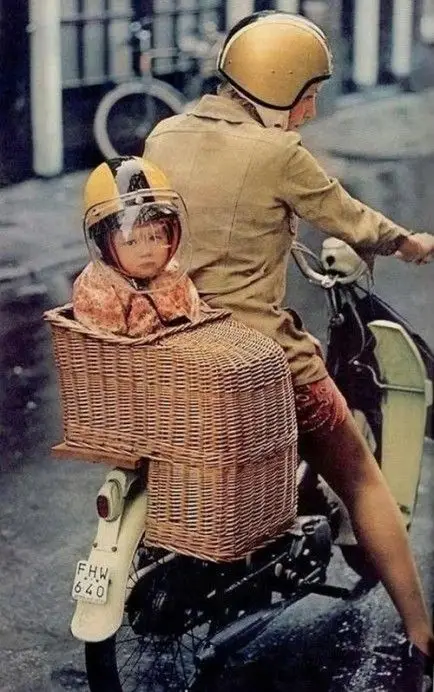 child in wicker bike seat on back of scooter
