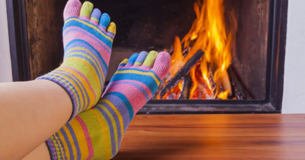 relaxing at fireplace in colorful funny toesocks
