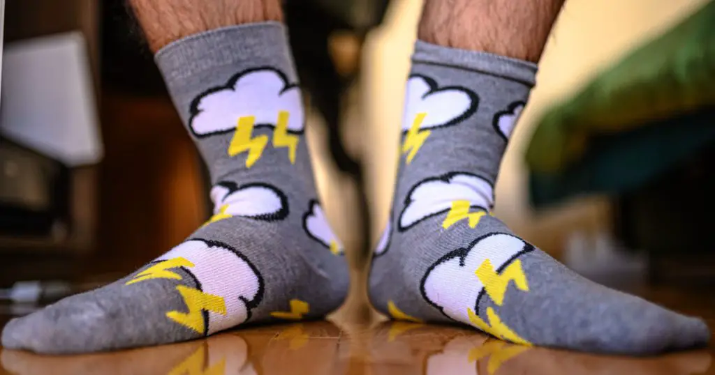 man wearing retro socks with clouds and lightning. new socks as a fashion accessory
