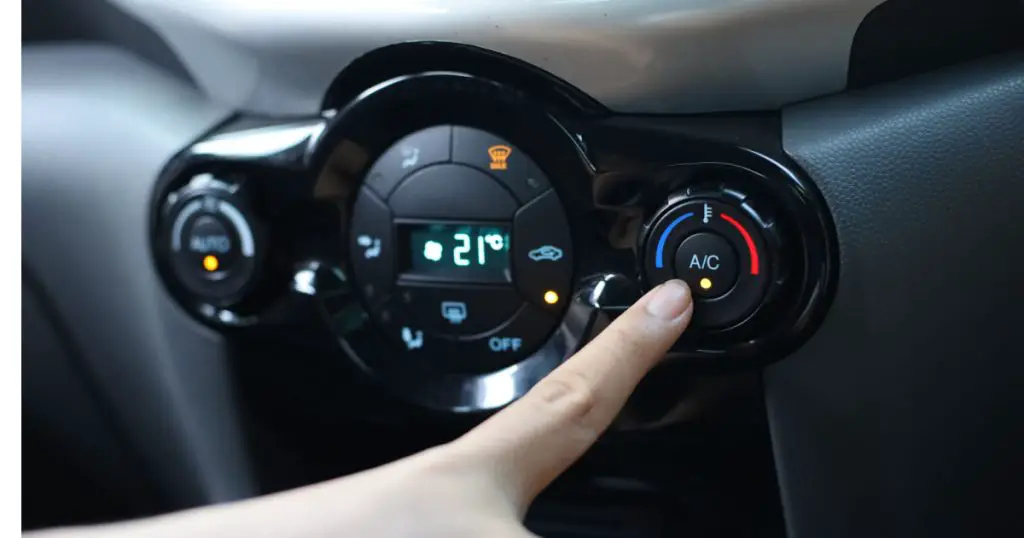 Finger pressing on Power button on off switch of a Car air conditioning and heating system To turn on the Fan of the AC inside the Car. auto climate control
