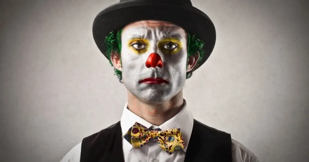 portrait of sad clown with bowler hat and red nose
