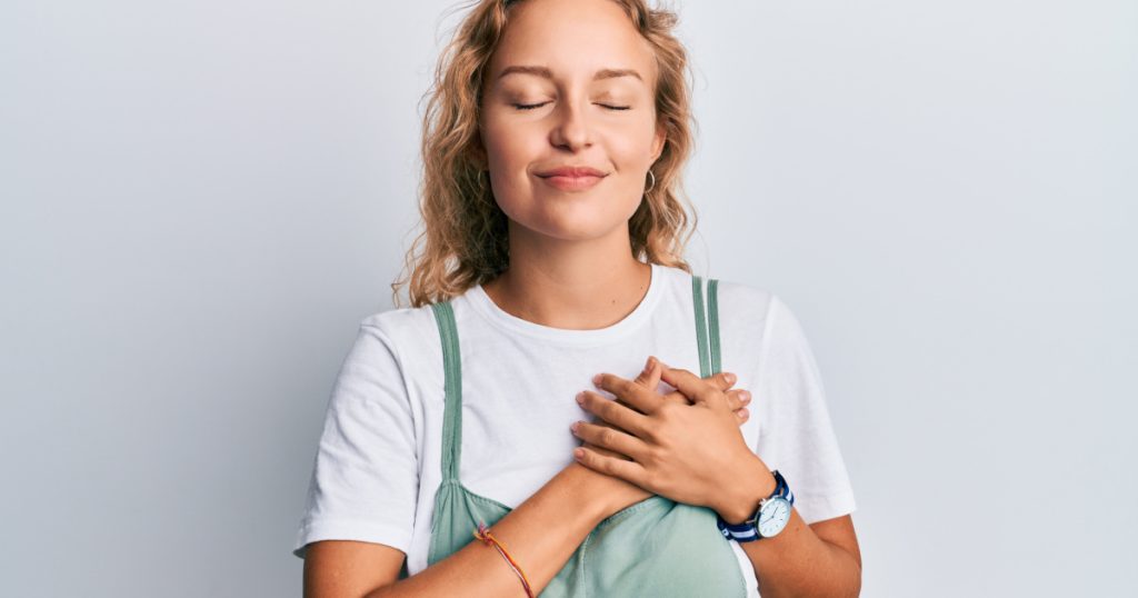 oman wearing casual clothes smiling with hands on chest with closed eyes and grateful gesture on face. health concept.