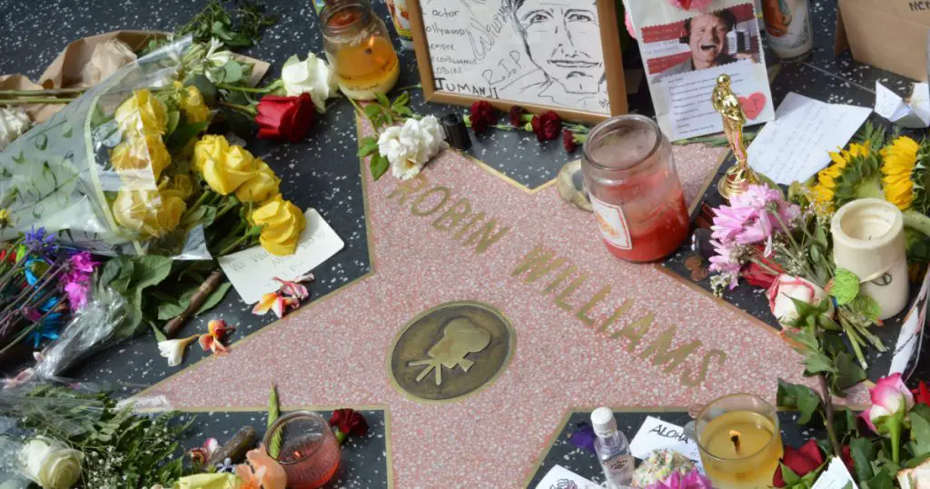 HOLLYWOOD, CA - AUGUST 12, 2014: Robin Williams' star on the Hollywood Walk of Fame is surrounded by flowers and various memorial tributes left by fans on August 12, 2014.
